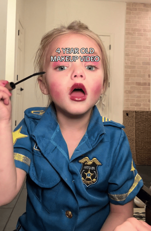 Cute little girl applying makeup