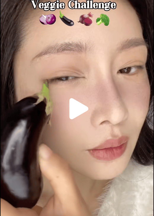 Asian woman applying makeup with an aubergine