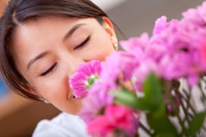 casual woman smelling gorgeous flowers at home